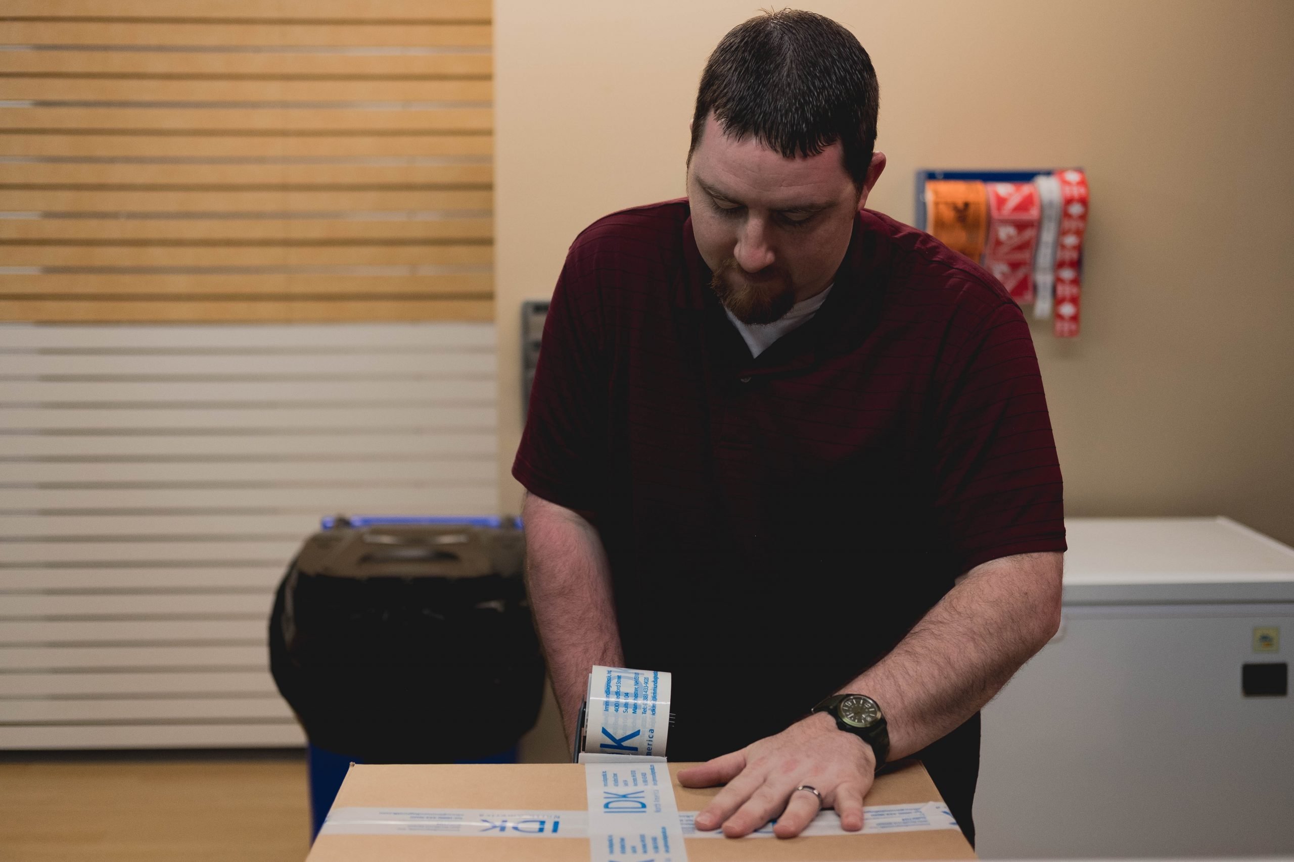 DSCF0430 IDK Inc's Logistics Manager Matt Romano taping up a box to be shipped out to a customer.