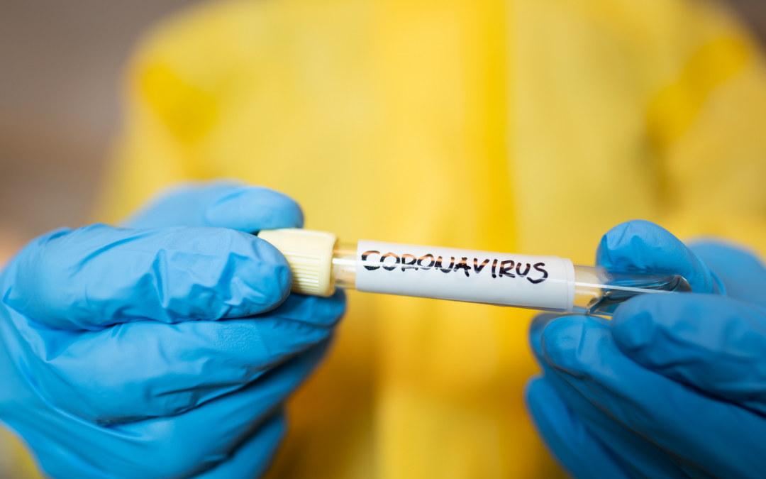 Gloved hands holding a vial labeled with Coronavirus.
