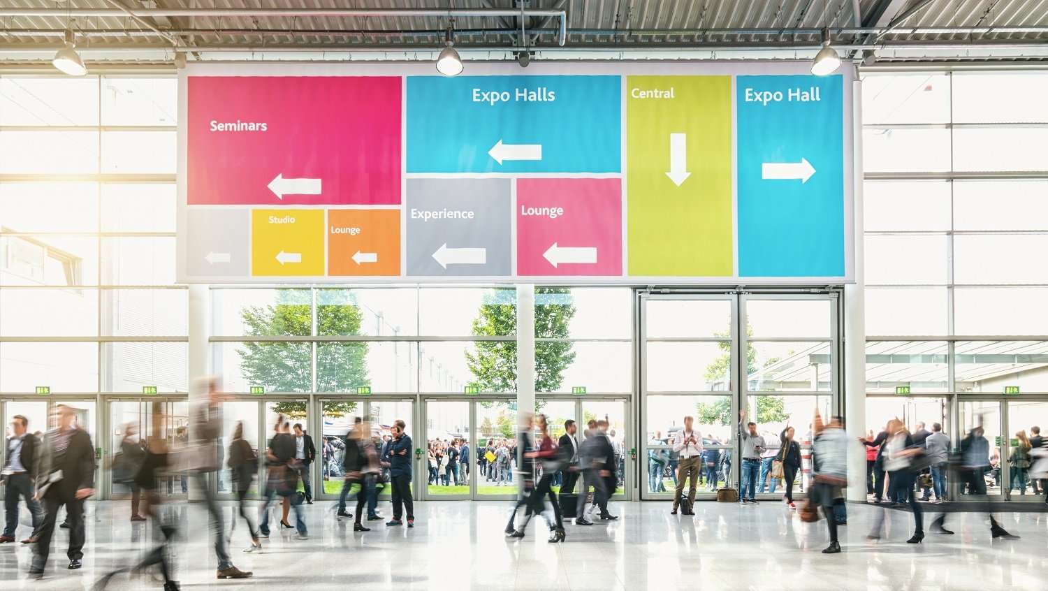 Anonymous,Crowd,Of,Business,People,At,A,Trade,Fair People walking through the lobby of a convention center.