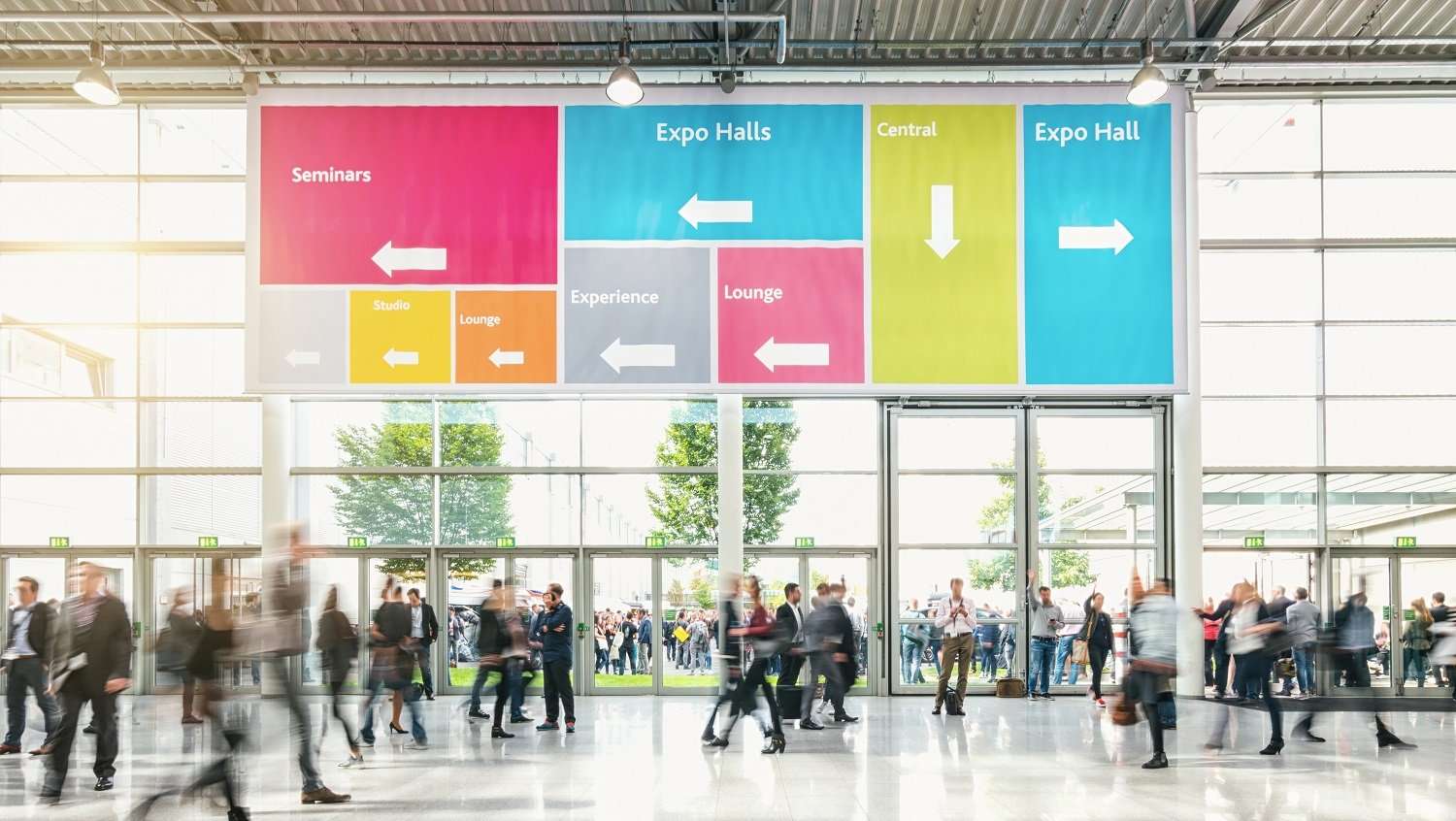 People walking through the lobby of a convention center.