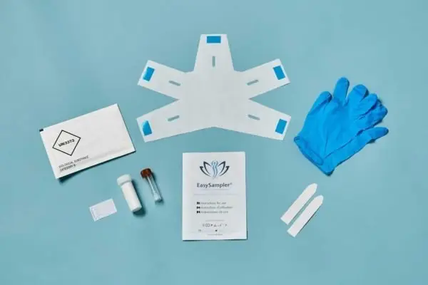 The contents of the EasySampler Complete Stool Collection Kit laid out on a blue surface.