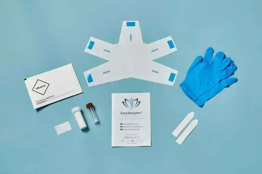 The contents of the EasySampler Complete Stool Collection Kit laid out on a blue surface.