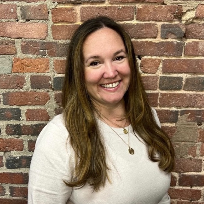 Technical Applications Scientist, Jamie Bolduc smiling in front of a brick wall.